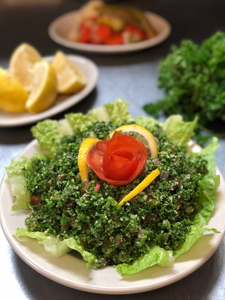 Fresh tabouleh salad served in a white bowl with parsley, bulgur, tomato, and lemon — authentic Middle Eastern vegetarian dish at Petra Restaurant Tampa. 