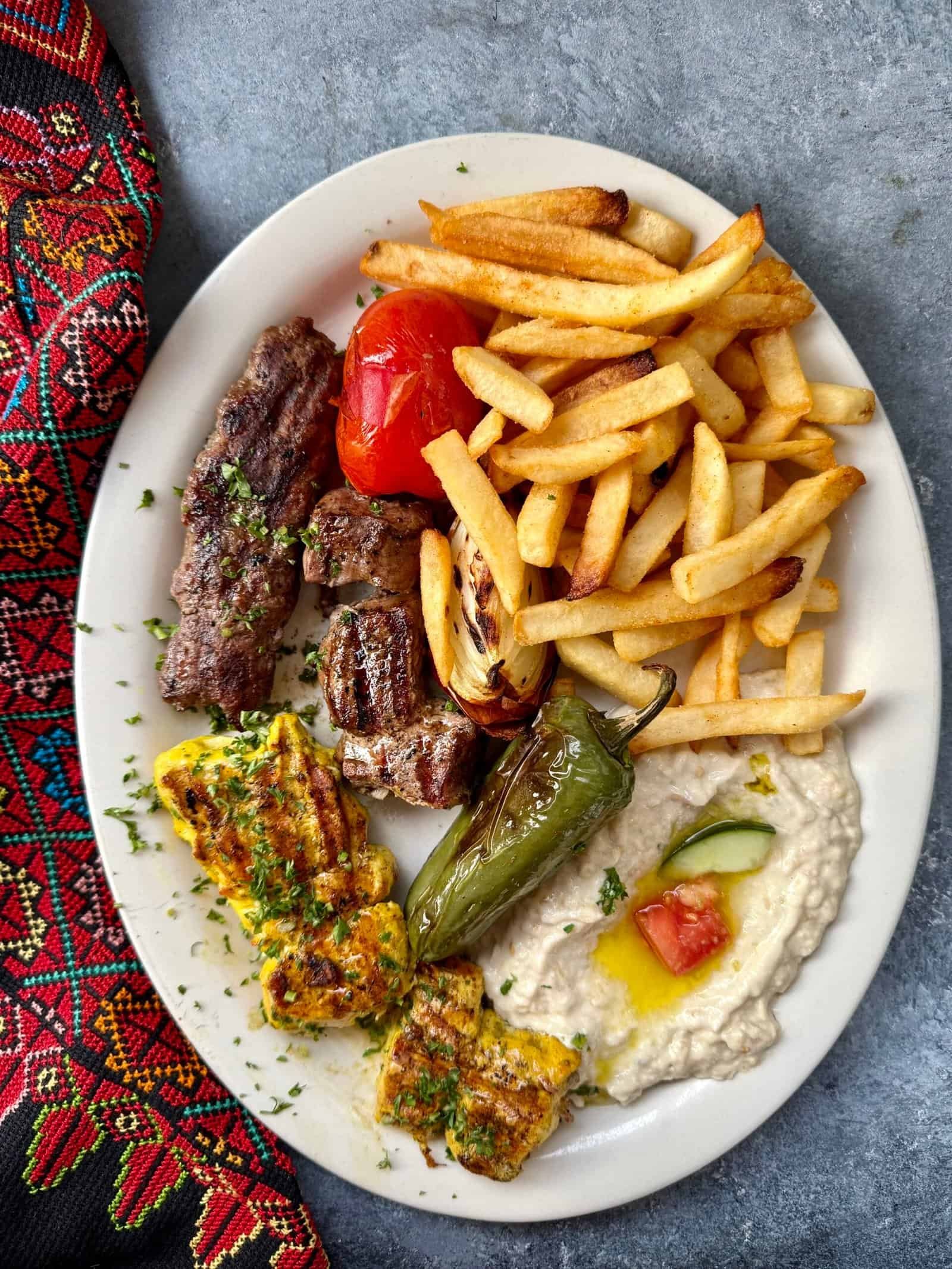 Petra Mixed Grill plate with chicken, beef kebabs, grilled vegetables, fries, and hummus – Mediterranean food in Tampa