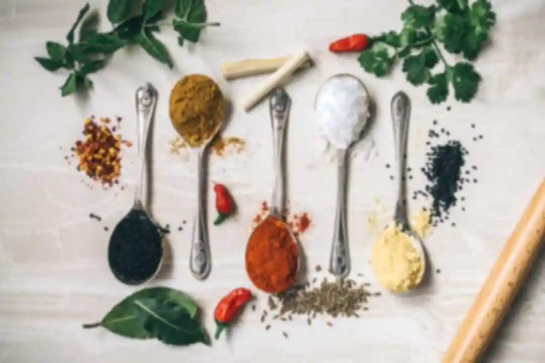 Flatlay of Middle Eastern and Mediterranean spices including turmeric, paprika, za'atar, cumin, and fresh herbs – Petra Restaurant Tampa