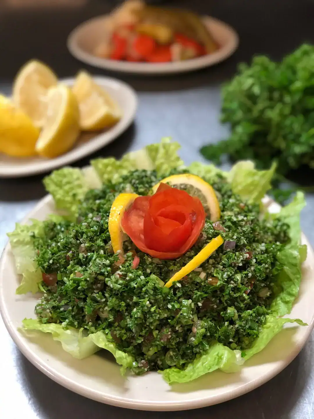 Fresh vegetarian tabouleh salad with parsley, bulgur, tomato, and lemon – Mediterranean dish at Petra Tampa