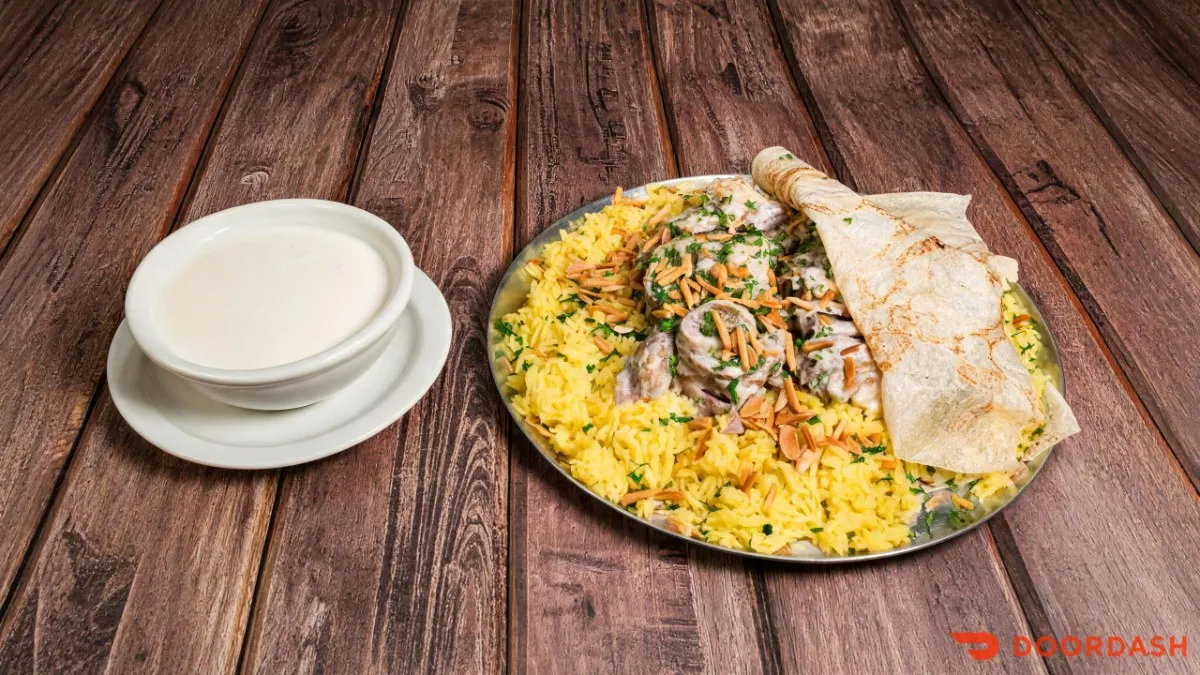 A plate of mansaf with lamb, rice and jameed sauce
